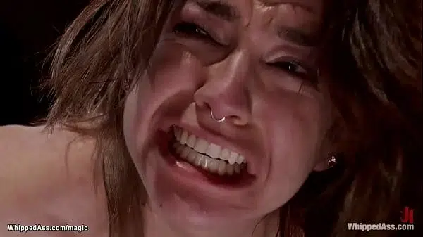 Bound brunette lesbian slave Bianca Stone is straddled on wooden pony then whipped and anal fucked with dick on a stick in hands of MILF Aiden Starr